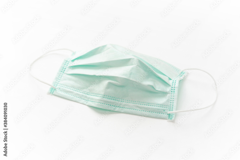 Surgical mask with rubber ear straps isolated on white background. White mask to cover the mouth and nose. Surgical mask with rubber ear straps isolated on white background. White mask to cover the mouth and nose.