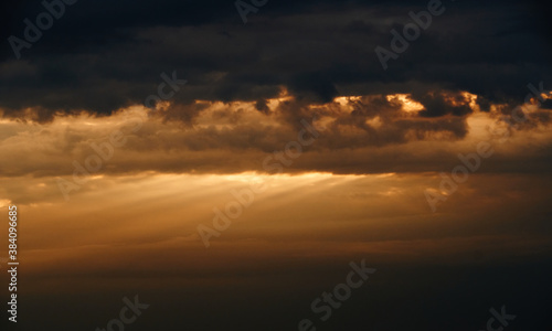beautiful sunset sky, bright sun and dark silhouette of clouds as a background © soleg