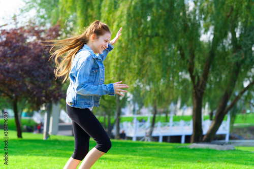 girl runs through a city park, bright summer day © soleg