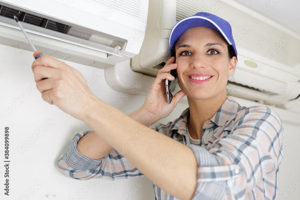 handywoman on the phone cleaning ventilation system handywoman on the phone cleaning ventilation system