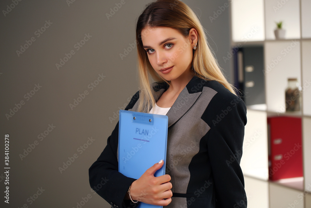 young girl looking at the camera while holding documents young girl looking at the camera while holding documents