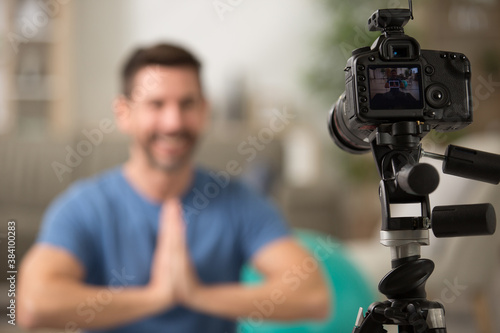 young male sport blogger recording video at home