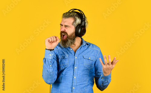 karaoke. singing and dancing. Enjoying his favorite music. Man listening music with his headphones. bearded man hipster in headset. Listening to music. Time to relax. brutal hipster wear earphone photo