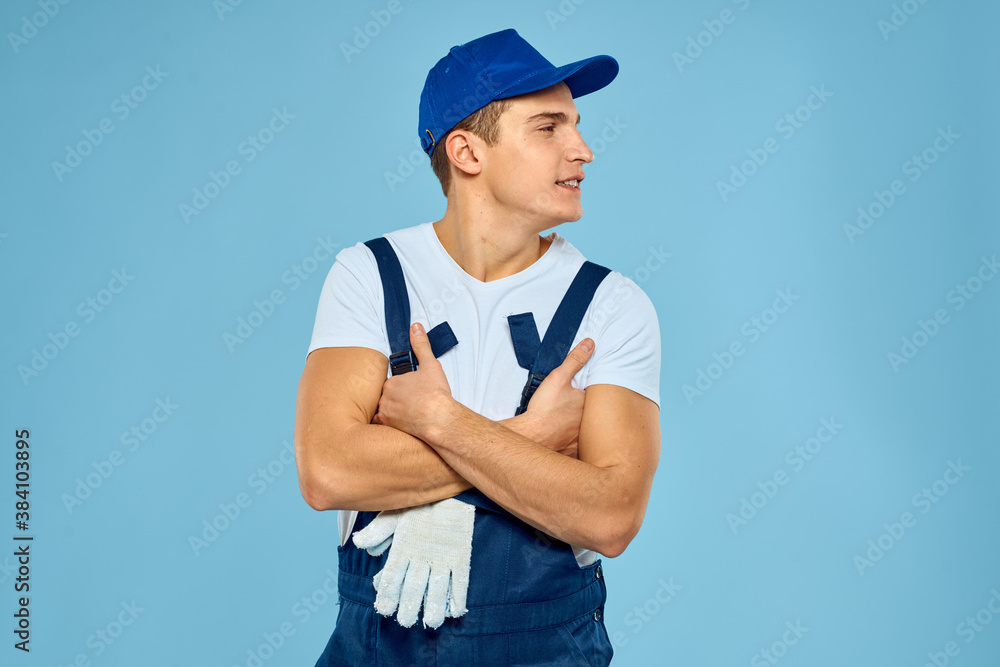 Working man in uniform of gloves loader rendering service blue background Working man in uniform of gloves loader rendering service blue background