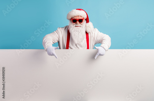 Portrait of his he nice attractive funky confident cool white-haired Santa demonstrating copy space board advice recommend look idea isolated over bright vivid shine vibrant blue color background