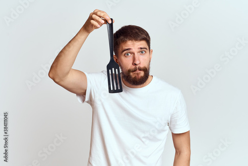 man with cooking shovel and white t-shirt close-up cropped view emotion gesturing with hand