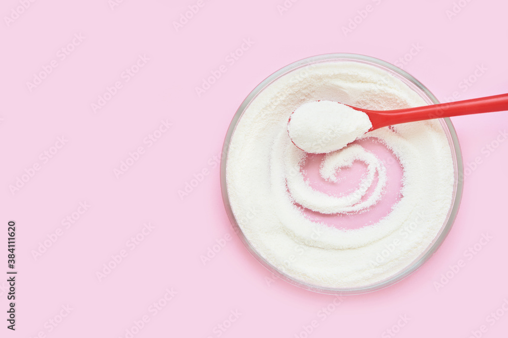 Fototapeta premium Collagen white powder. Pastel color background. Health product. Woman cosmetics concept. Sport supplement. Skincare cosmetics. Pink monochrome. Spoon