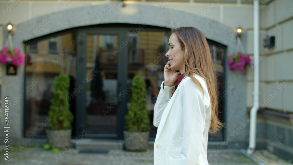 Smiling businesswoman calling phone outdoors. Serious business woman