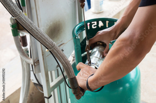 Employees use equipment to fill the tank with gas.