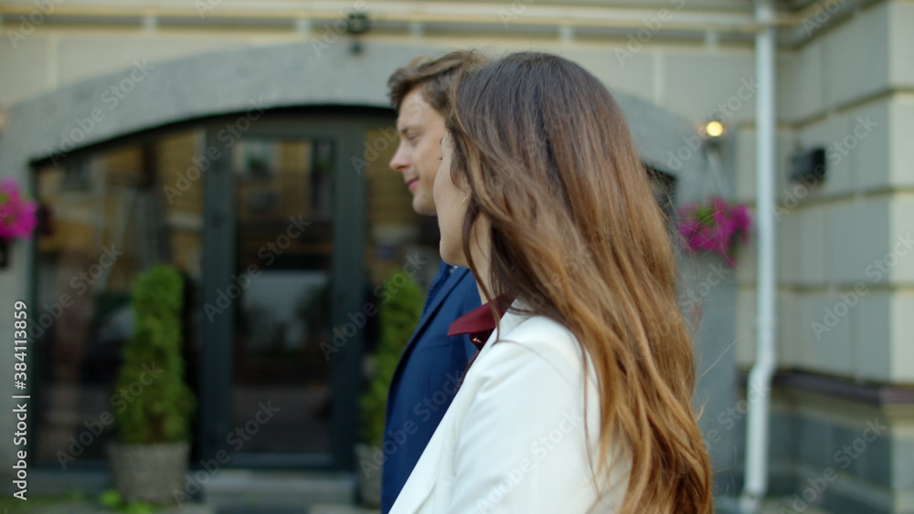 Fototapeta premium Cheerful business couple walking outdoors. Happy partners walking to office