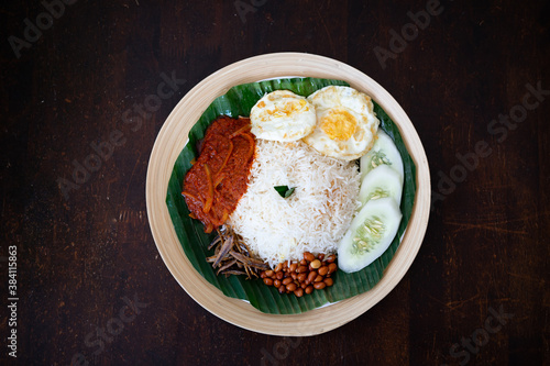 Canvas Print Traditonal Malaysia Asian food Nasi Lemak on a banana leaf in a wooden bamboo plate
