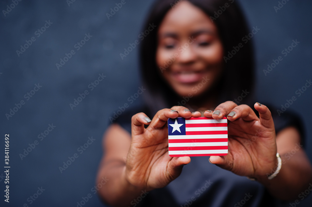 Proud to be liberian. African woman hold small Liberia flag in hands. Proud to be liberian. African woman hold small Liberia flag in hands.