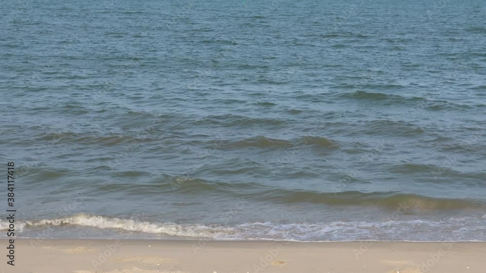 Wind blowing over sea waves on the beach in daytime. The waves hitting the empty sandy beach.
Wind blowing over sea waves on the beach in daytime. The waves hitting the empty sandy beach.