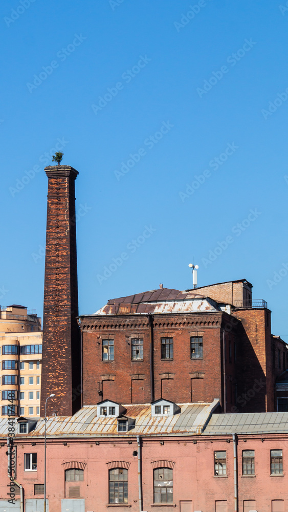 Old factory against blue sky. industrial building with chimney