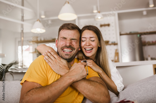 Happy man looking at a watch given by his girlfriend at home