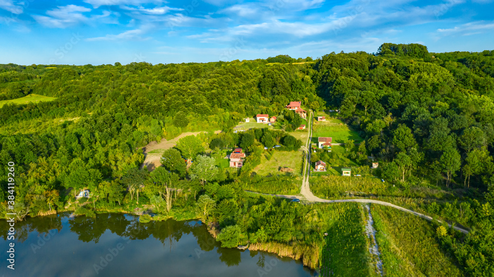 Aerial view of houses, weekend resort in wood near lake dam, water