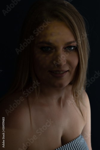 Beautiful mid adult woman with interesting pattern of light on her face and body. Beauty female portrait.