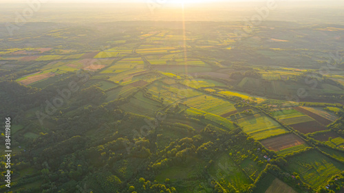 Sunrise backlight in aerial view over woodland  Sun rays in sunflare backlight  misty morning