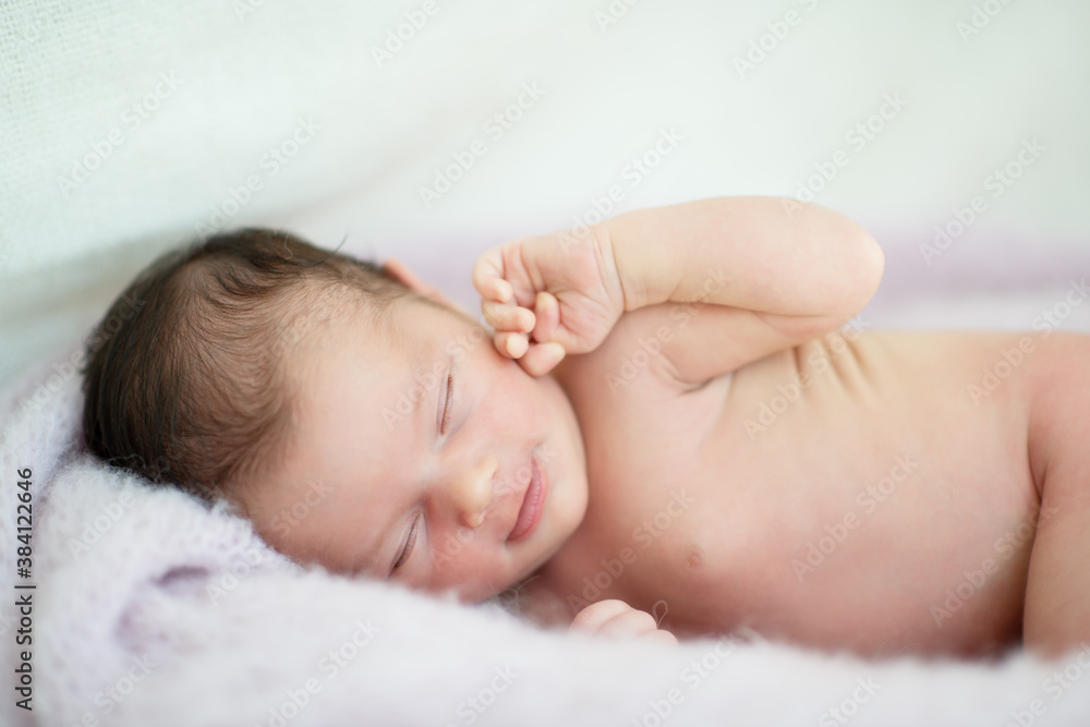 New born baby girl sleeps at home and smiling in a dream. Cute little kid's portrait New born baby girl sleeps at home and smiling in a dream. Cute little kid's portrait