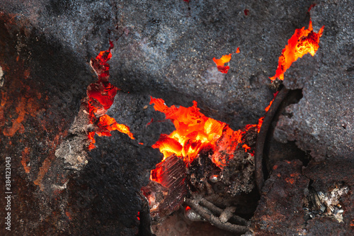 Coals from a fire in a rusty iron barrel.
