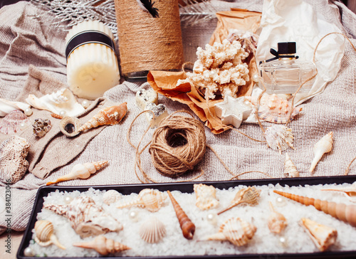 a lot of sea theme in mess like shells, candles, perfume, girl stuff on linen, pretty textured post card view vintage photo