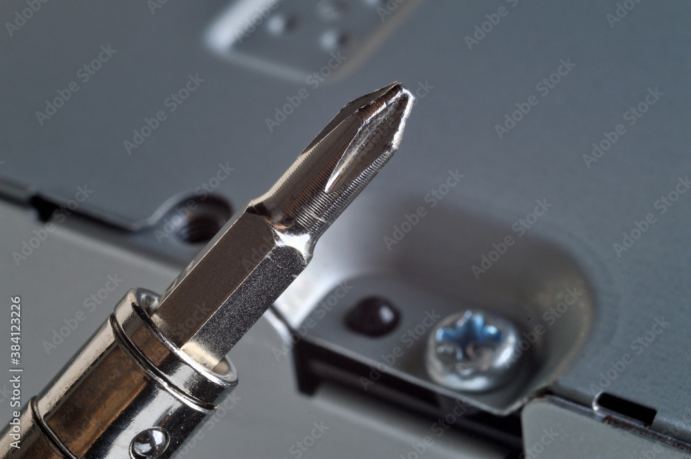 disassembling a metal computer case with a small screwdriver. close-up