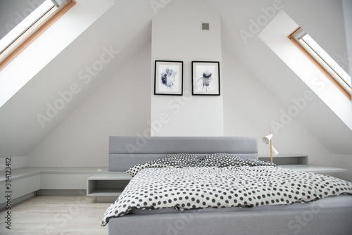 Schilderij op canvas Modern monochrome design home interior of bedroom room in mansard with wooden bed and elegant accessories