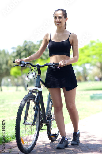 Young fitness woman with bicycle photo