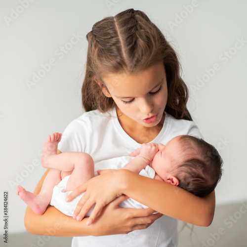 Obraz na płótnie Little girl holding newborn baby sister in her arms
