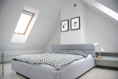 Tableau sur toile Modern monochrome design home interior of bedroom room in mansard with wooden bed and elegant accessories