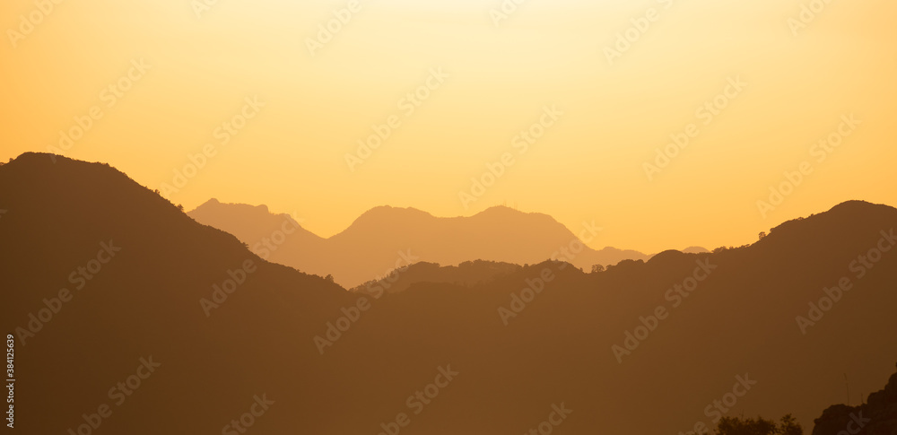 Mountain range silhouette in warm sunset colors