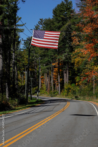 Cornwall, Connecticut USA An American flag hangs above a country road.