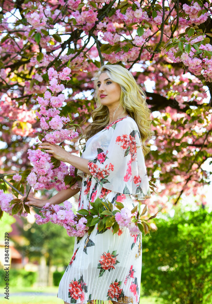 Enjoying summer rest. female flower perfume. beauty of spring nature. attractive woman with makeup. girl has long curly blonde hair. healthy beauty. pink sakura flowers. natural beauty and cosmetics Enjoying summer rest. female flower perfume. beauty of spring nature. attractive woman with makeup. girl has long curly blonde hair. healthy beauty. pink sakura flowers. natural beauty and cosmetics