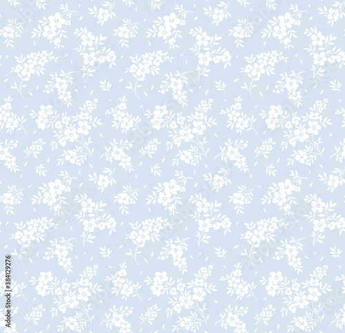 Vintage floral background. Seamless vector pattern for design and fashion prints. Flowers pattern with small white flowers on a light blue background. Ditsy style.