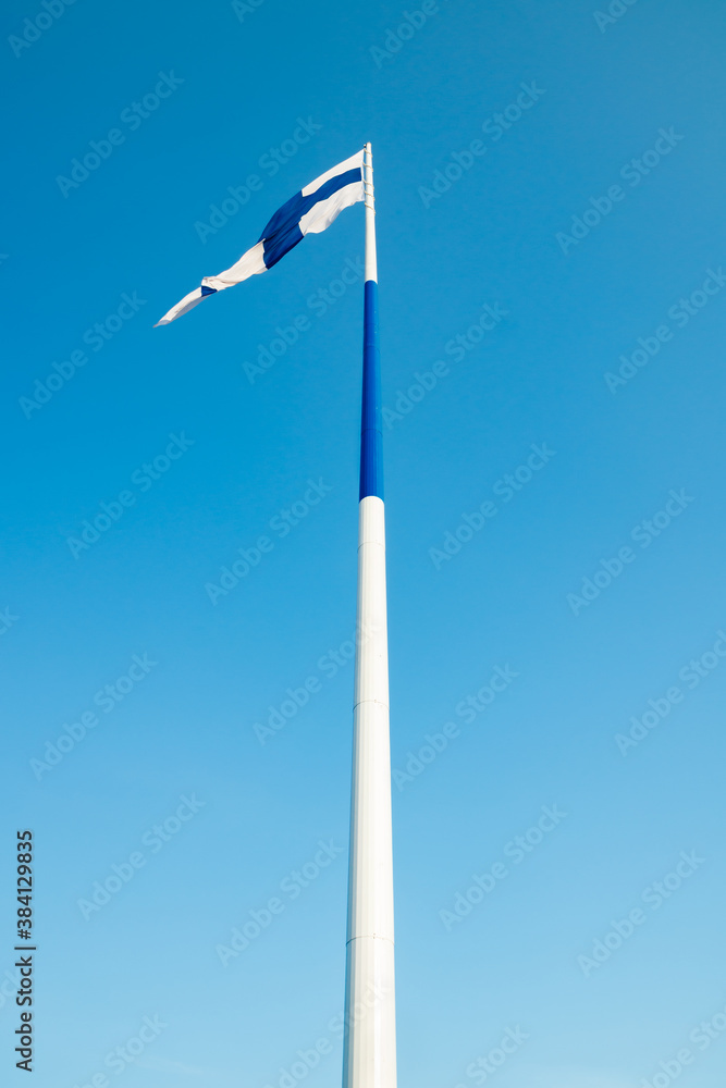 The largest finnish flag in the world and the tallest flagpole in Europe against blue sky, Hamina, Finland. The flag pole is 100 meter high. The largest finnish flag in the world and the tallest flagpole in Europe against blue sky, Hamina, Finland. The flag pole is 100 meter high.