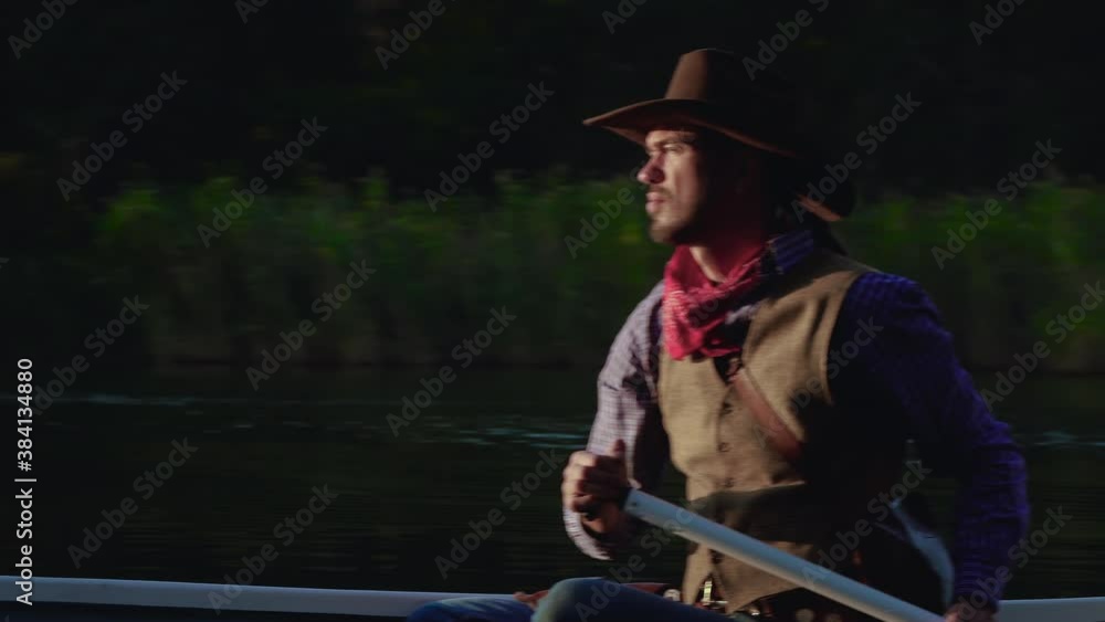 A cowboy in a red canoe floats on the river. Historical reconstruction of life in the wild west of America. 4K A cowboy in a red canoe floats on the river. Historical reconstruction of life in the wild west of America. 4K