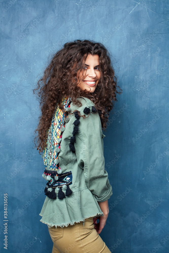 young pretty woman with curly brunette hair posing cheerful on blue background, lifestyle people concept young pretty woman with curly brunette hair posing cheerful on blue background, lifestyle people concept
