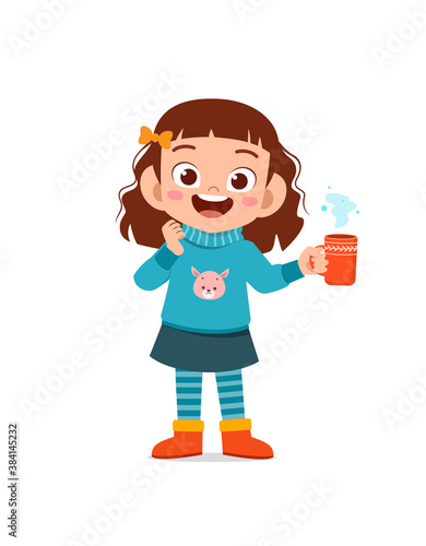 happy cute little kid drink hot chocolate in winter season. child drink milk wearing warm clothes