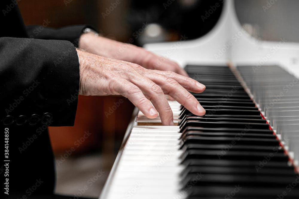 Caucasian male playing a grand piano