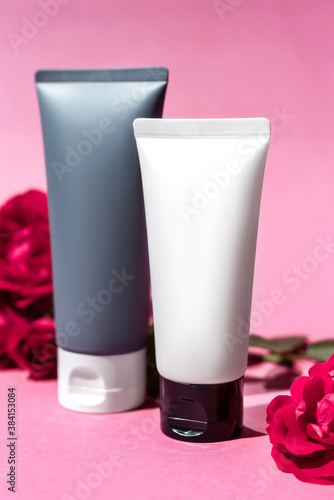 Bottle  tube  jar of cream or lotion with pink roses and on a pink background. Organic cosmetic. Treatment spa beauty skincare healthcare. Brand commercial. Product. Mock up cosmetics