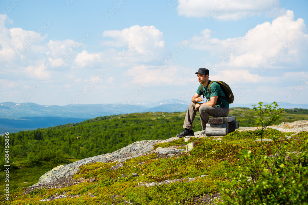 Man resting and looking out in the Swedish northern nature during summer. Man resting and looking out in the Swedish northern nature during summer.