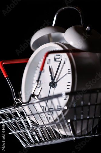 Red shopping basket with white retro alarm clock in it. Lose time. Buy time. Break. Motivation. Business solutions. Success. Deadline.