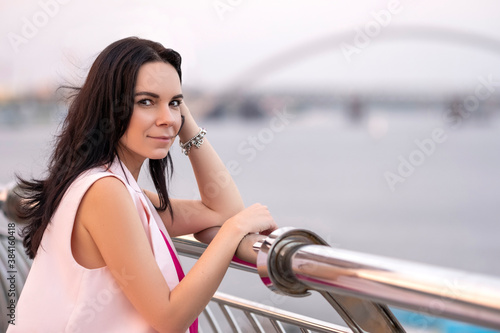 Btunette beautiful woman on a walk on european streets. Summer evening portrait with a suncet light. Space for text. photo