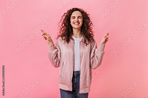 Curly woman in stylish jacket crossed fingers