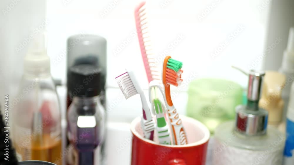 A Hand Protected by Glove Opens the Bathroom Cabinet Drawer and Takes a Toothbrush A Hand Protected by Glove Opens the Bathroom Cabinet Drawer and Takes a Toothbrush