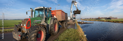 Dredging of inland canals by pushboat and crane; the dredging spoil is deposited in a tipper trailer photo