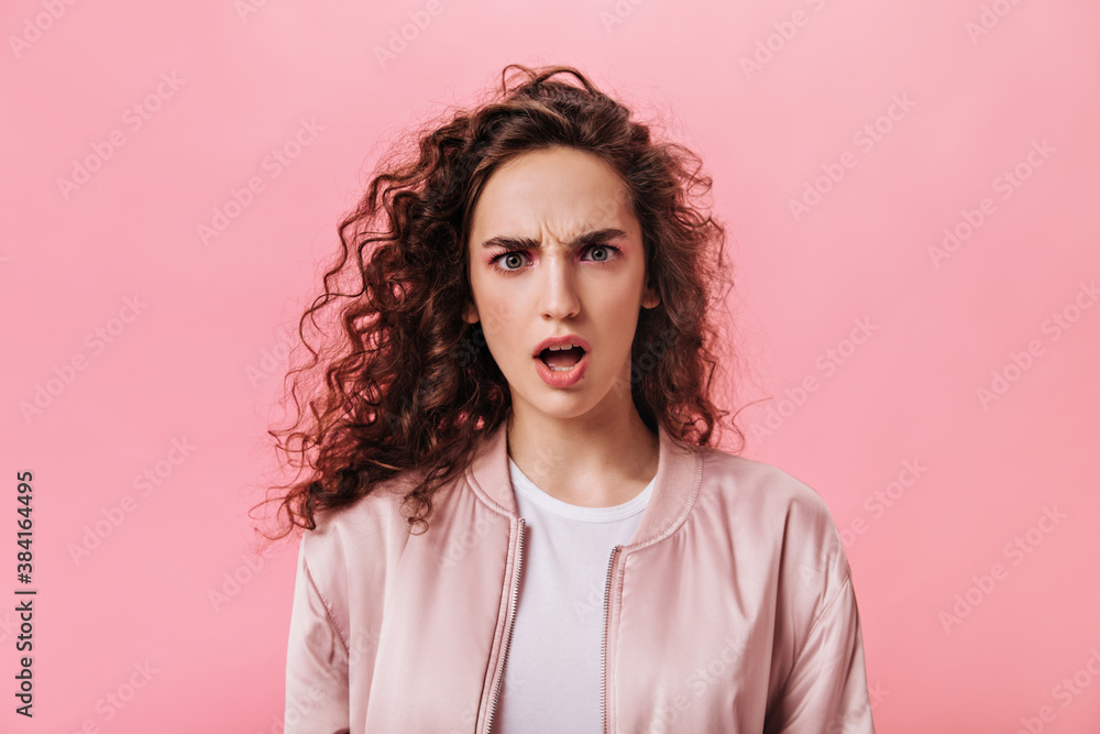 Lady looks at camera shocked on pink background Lady looks at camera shocked on pink background