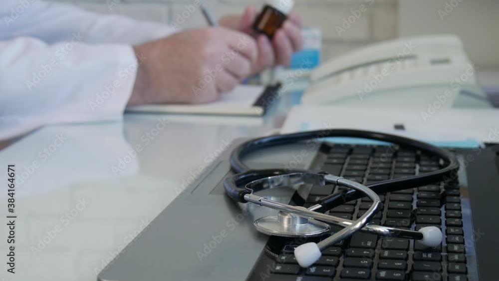 Slow Motion Doctor looking to some medication and prescribing a treatment, physician write a medical recipe in the hospital consultation room Slow Motion Doctor looking to some medication and prescribing a treatment, physician write a medical recipe in the hospital consultation room