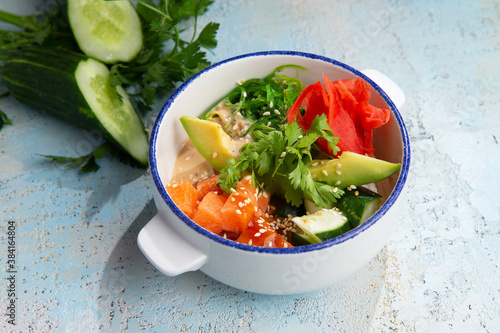 salmon tartare with avacado and herbs in a plate photo