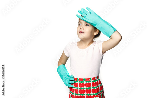 Little girl in green rubber gloves ready for cleaning. Wipes sweat from his forehead after harvesting isolated on a white background.
